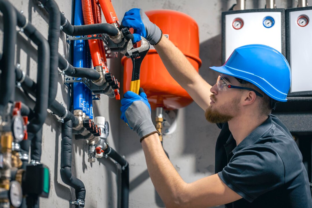man-installs-heating-system-house-checks-pipes-with-wrench_169016-55834